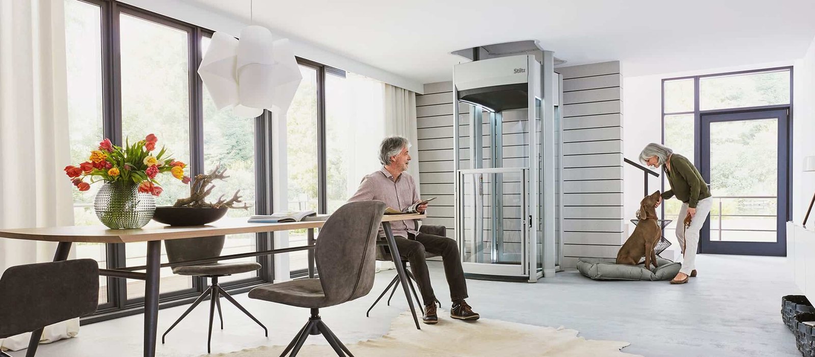 Couple using a Stiltz home lift in their living room